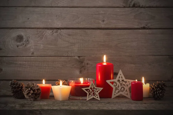 Decorazione natalizia con candele rosse su sfondo di legno — Foto Stock