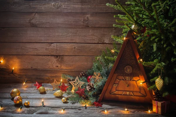 Vintage clock with Christmas tree on wooden background — Stock Photo, Image