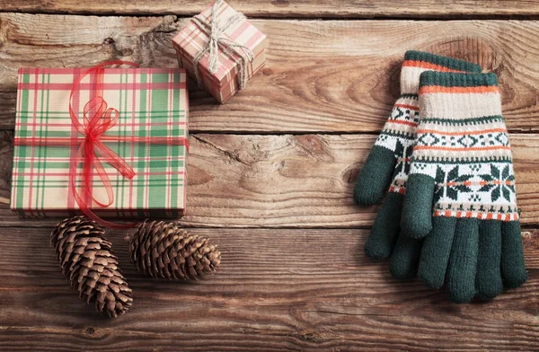Різдвяні подарунки та рукавички на дерев'яному фоні — стокове фото