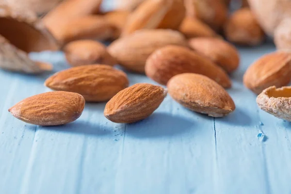 Almendras saladas en cáscara sobre fondo de madera —  Fotos de Stock