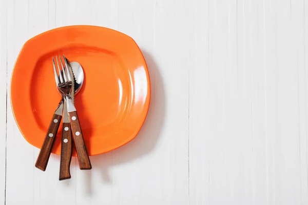 Orange plate on white wooden background — Stock Photo, Image
