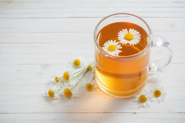 Taza de té con manzanilla sobre fondo de madera blanca — Foto de Stock