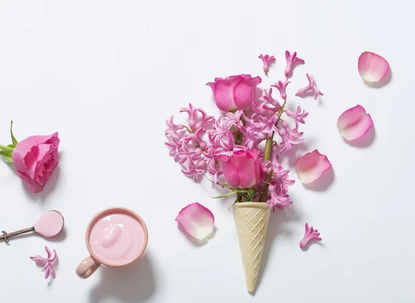 Flores en un cono de gofre con yogur sobre fondo blanco — Foto de Stock