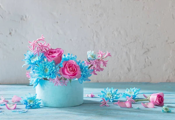 Flores azules y rosadas en caja sobre mesa de madera — Foto de Stock