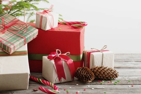 Kerstcadeaus en kegels op houten achtergrond — Stockfoto