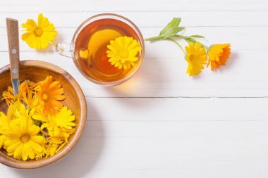 Beyaz ahşap masa Calendula (kadife çiçeği) bitkisel çay
