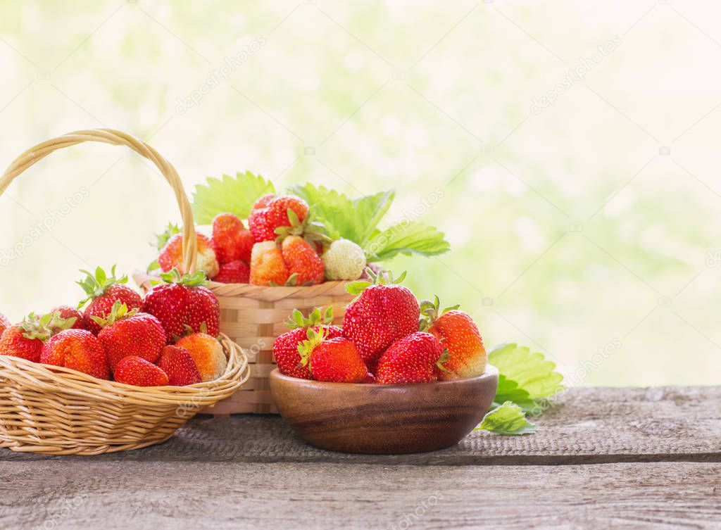 strawberries in baskets on wooden table outdoor