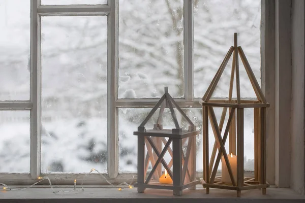 Linterna de madera en el alféizar de la ventana en el paisaje de invierno de fondo — Foto de Stock