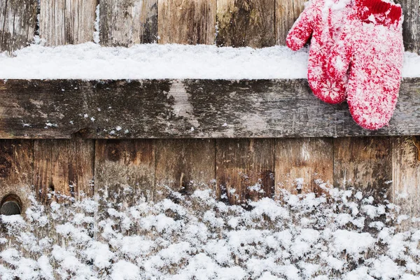 Fundo de madeira velho com neve e mitenes — Fotografia de Stock