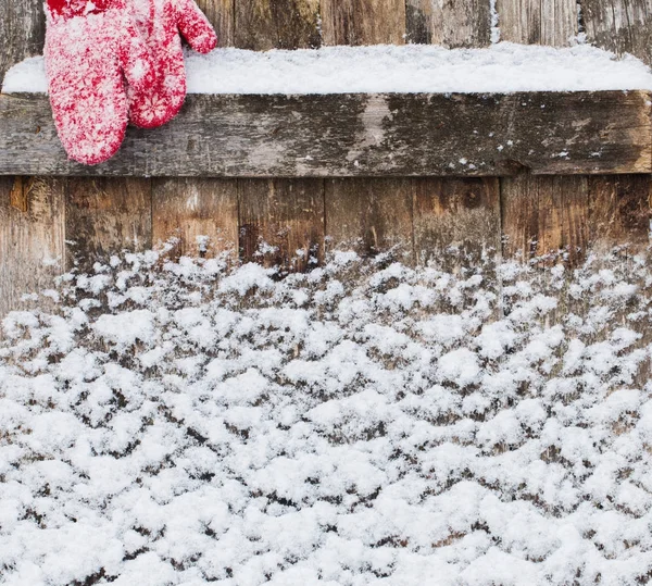 Старий дерев'яний фон зі снігом і рукавицями — стокове фото