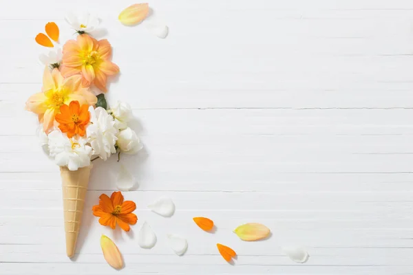 Flores en cono de gofre sobre fondo de madera blanca — Foto de Stock