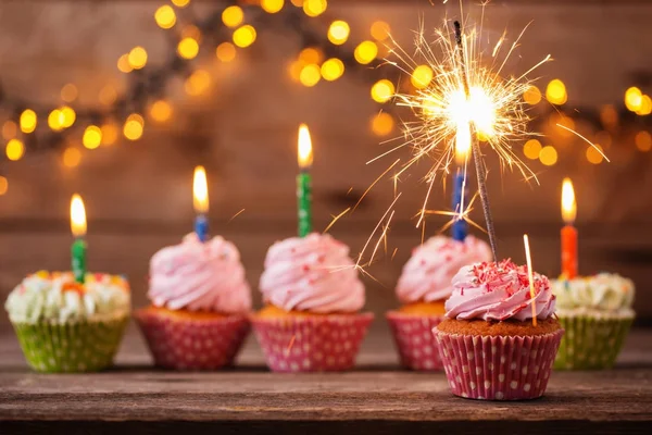 Cupcake com sparkler no fundo de madeira velho — Fotografia de Stock