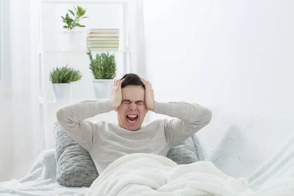 En man med huvudvärk på soffan — Stockfoto