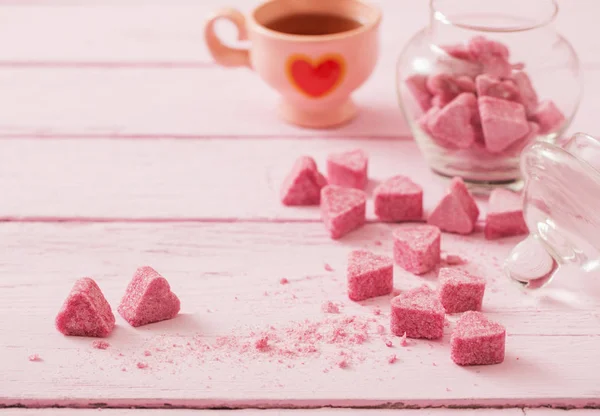 Açúcar rosa granulado em forma de coração e xícara de chá em — Fotografia de Stock
