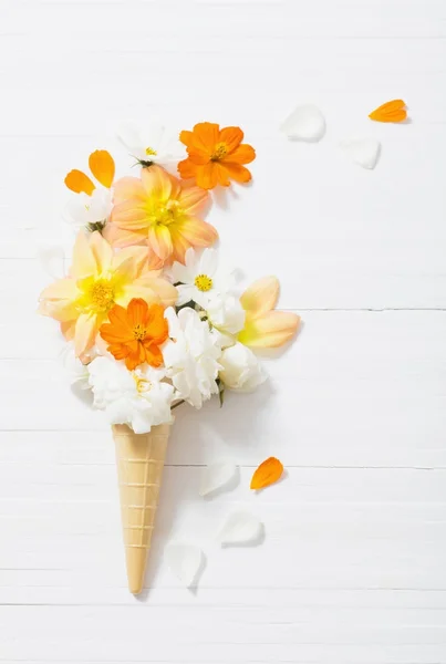 Flores en cono de gofre sobre fondo de madera blanca — Foto de Stock