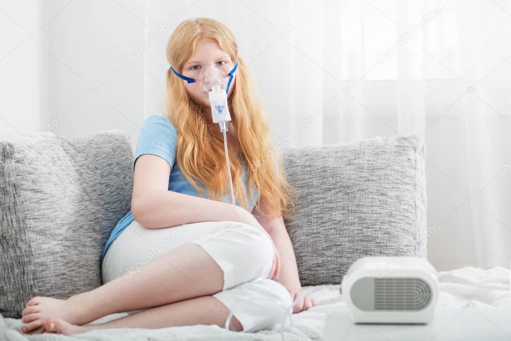 teenager girl doing inhalation indoor