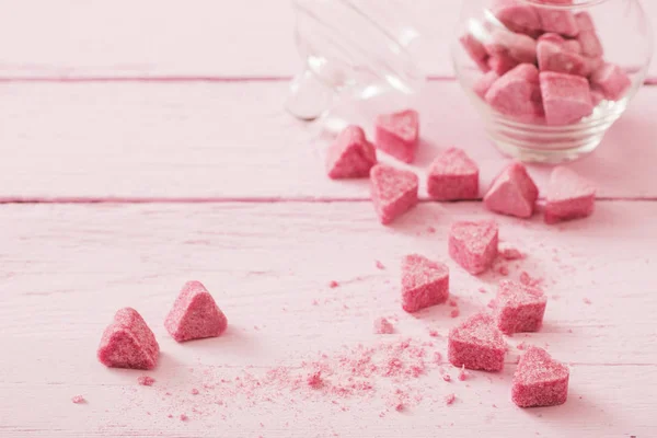 Açúcar rosa granulado em forma de coração em um backgro de madeira — Fotografia de Stock
