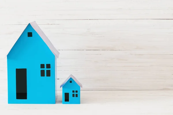 Casas de papel azul no fundo de madeira branco — Fotografia de Stock