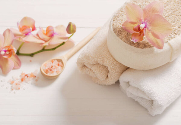 orchid with towels on white wooden background