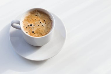 Beyaz masada bir fincan kahve.