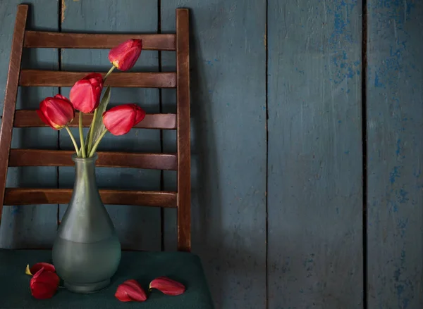 Красные тюльпаны в вазе на старом деревянном фоне — стоковое фото