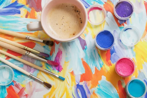 Verf, penselen en kopje koffie op papier — Stockfoto