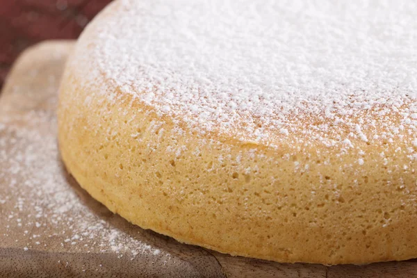 Bolo de esponja na velha mesa de madeira — Fotografia de Stock