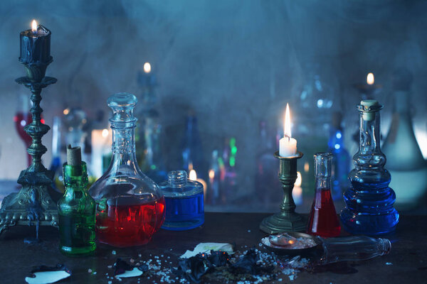 Волшебное зелье, древние книги и свечи на темном фоне
