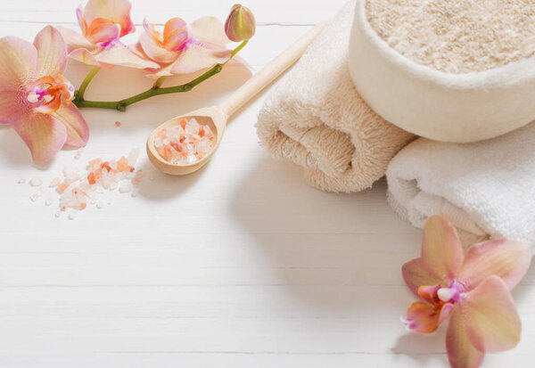 orchid with towels on white wooden background