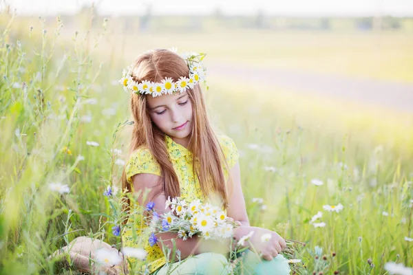 Vacker flicka med kamomill på gräs — Stockfoto