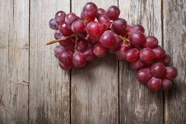 Red grape on old wooden background — Stock Photo, Image