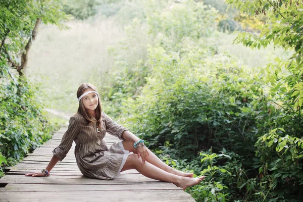 Sonrisa adolescente chica en viejo madera puente — Foto de Stock
