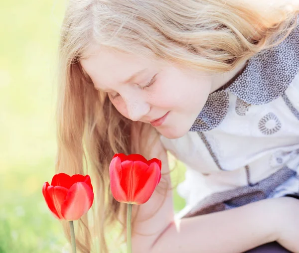 Sorriso menina com tulipas ao ar livre — Fotografia de Stock