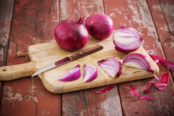 Rote Zwiebel auf altem hölzernen Hintergrund — Stockfoto