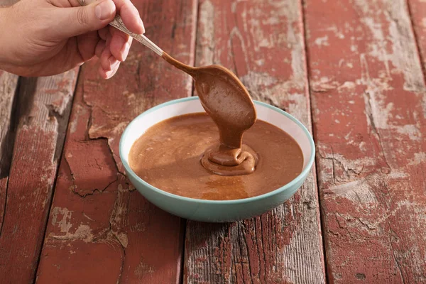 Шоколадне тісто в тарілці на старому дерев'яному столі — стокове фото
