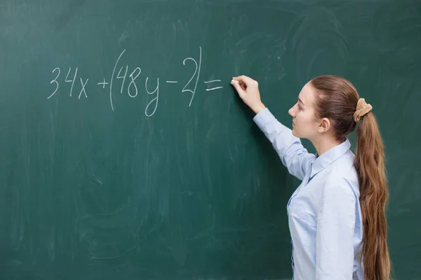 Dziewczyna na tablicy w klasie matematyki — Zdjęcie stockowe
