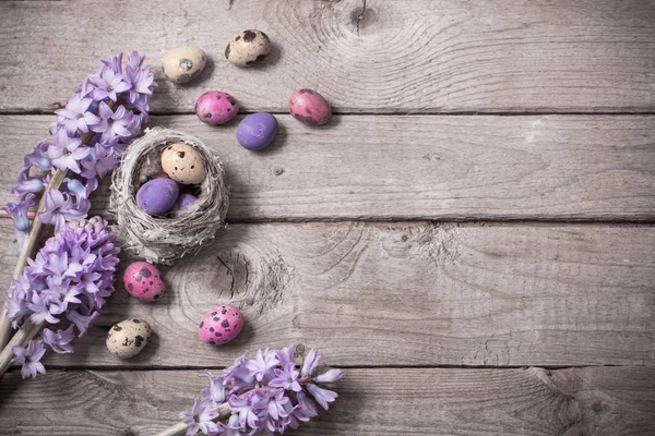 Uova di Pasqua con fiori primaverili su sfondo di legno — Foto Stock