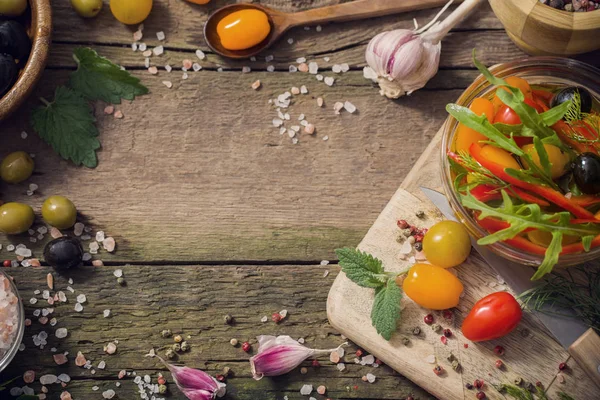 Vegetables and olives on old wooden background — Stock Photo, Image