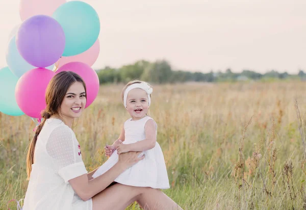Ευτυχισμένη μητέρα και κόρη με μπαλόνια εξωτερική — Φωτογραφία Αρχείου