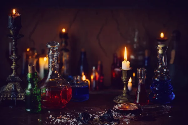 Pozione magica, libri antichi e candele su sfondo scuro — Foto Stock