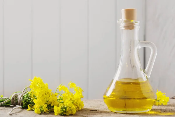 菜種油(菜種油)と菜の花の木のテーブル — ストック写真