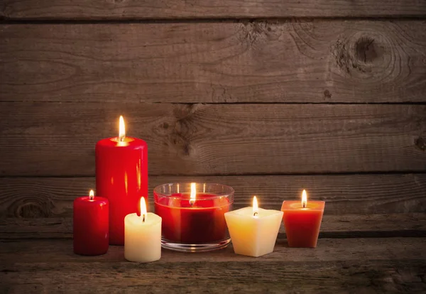 Candele rosse e bianche su sfondo di legno scuro — Foto Stock