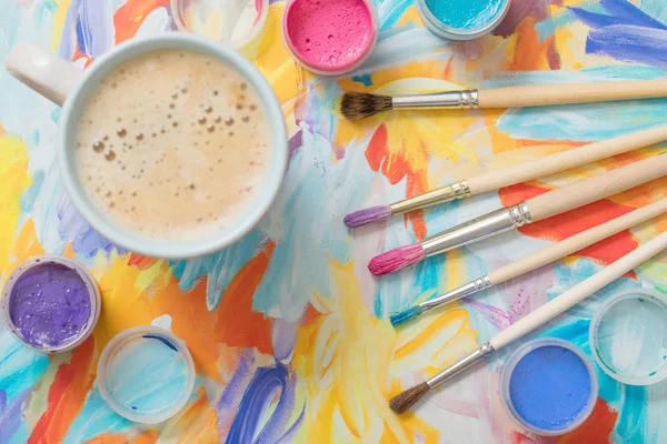 Tintas, pincéis e xícara de café sobre papel — Fotografia de Stock