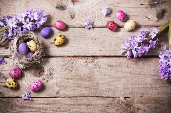 Uova di Pasqua con fiori primaverili su sfondo di legno — Foto Stock