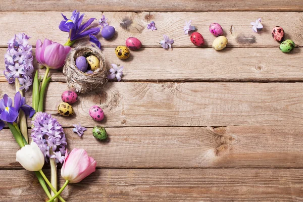 Uova di Pasqua con fiori primaverili su sfondo di legno — Foto Stock