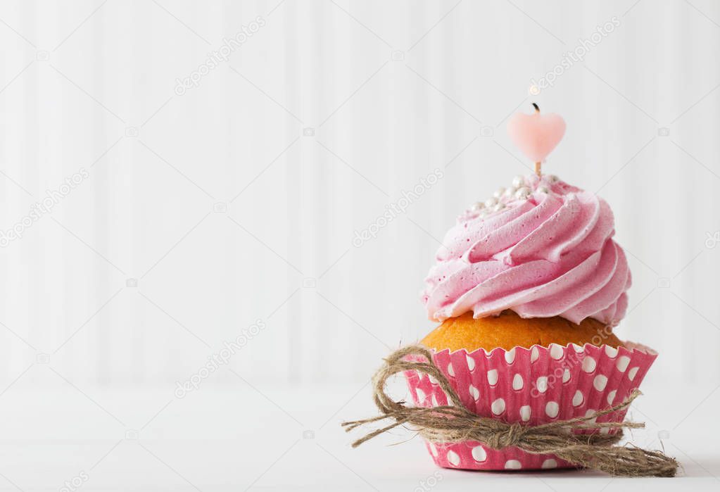 pink cupcake on white wooden background