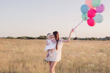 mutlu anne ve kızı gün batımında Balonlu