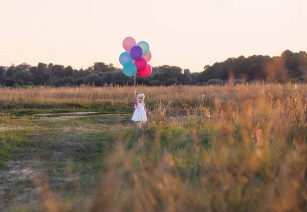 Balonlu açık beyaz elbiseli küçük kız — Stok fotoğraf