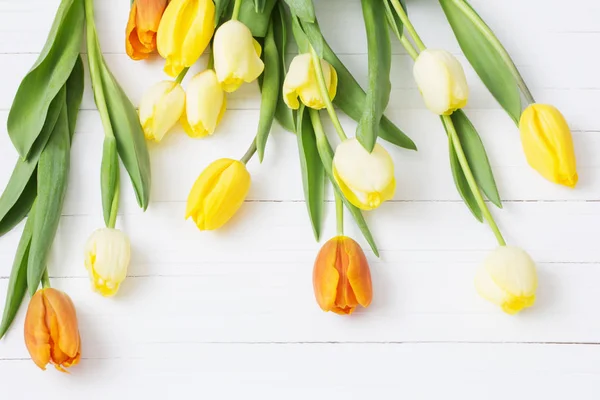 Žluté tulipány na dřevěné pozadí — Stock fotografie