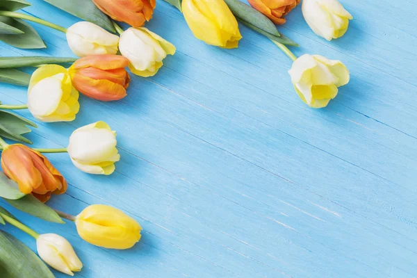 Žluté tulipány na dřevěné pozadí — Stock fotografie